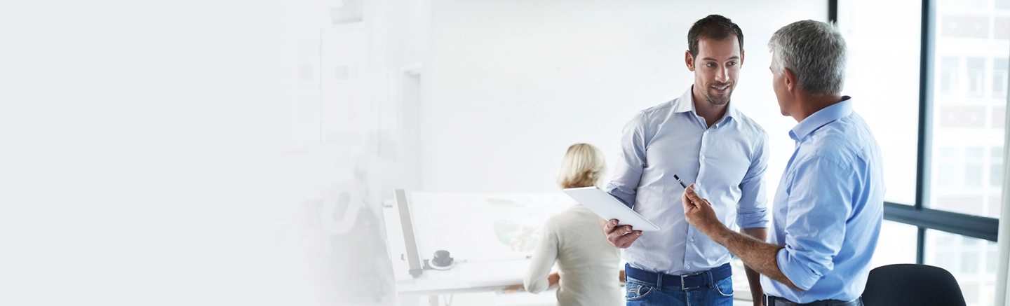 Men talking in office and using tablet device