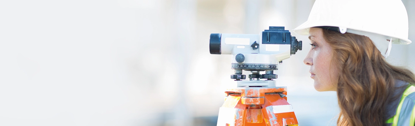 Woman looking through surveying equipment