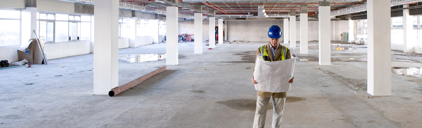 Man looking at designs on construction site