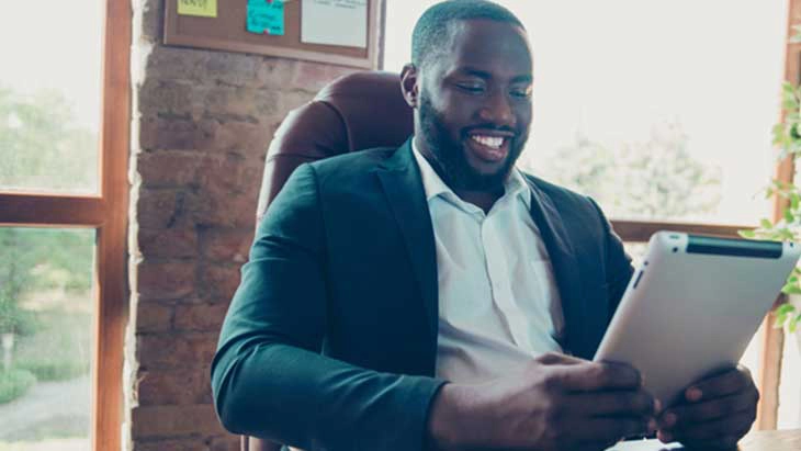 Man sitting in front of window reading from tablet