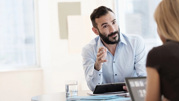 Man speaking to woman in office