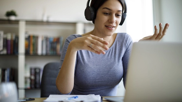 Woman with headphones working at lap top