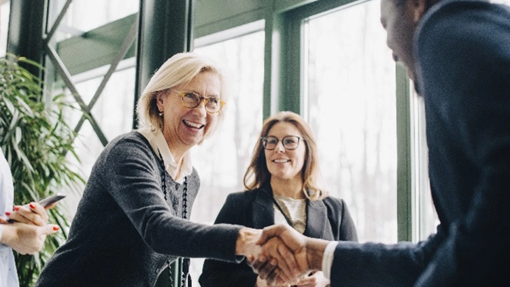 Colleagues shaking hands and smiling