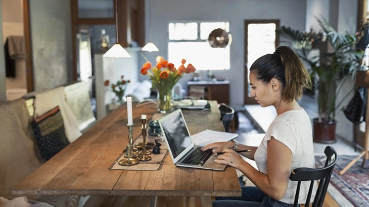 Woman working at table on laptop