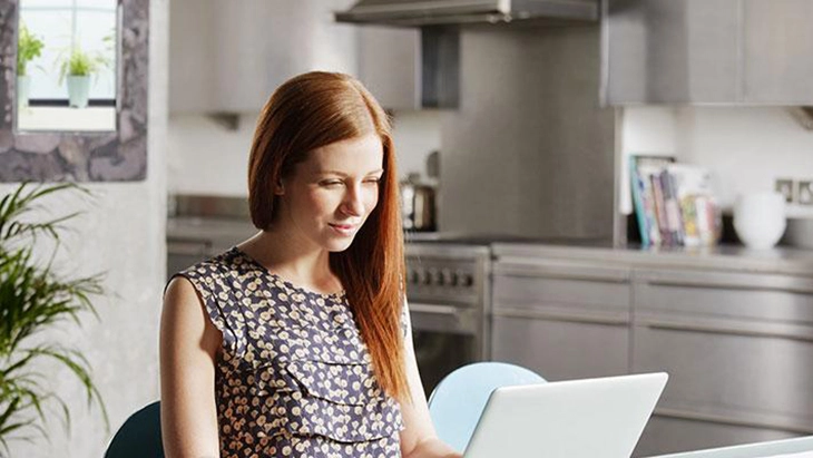 women sitting at her desk working on laptop