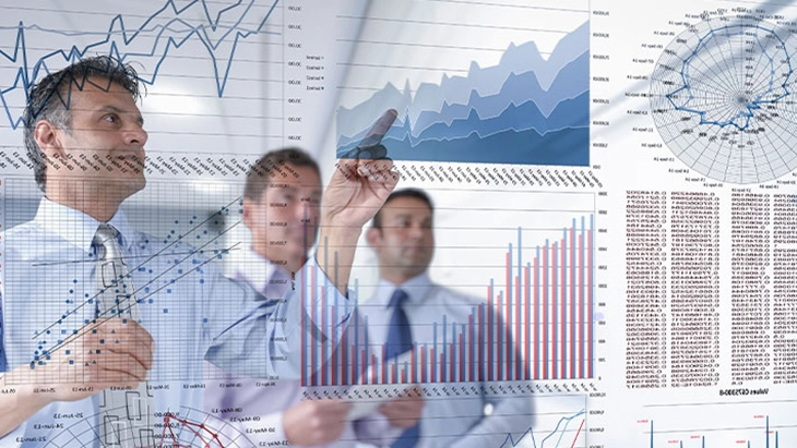 Three men looking at glass wall full of business charts and tables