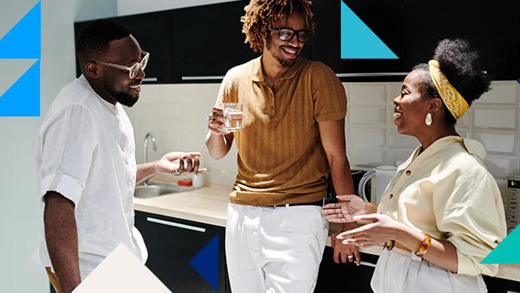 Colleagues laughing and talking in kitchen