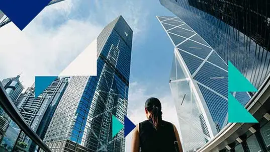 Person looking up at skyscrapers