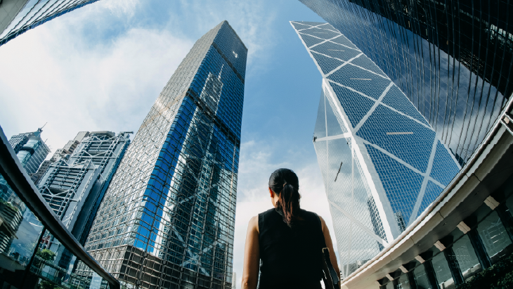 Person looking up at skyscrapers