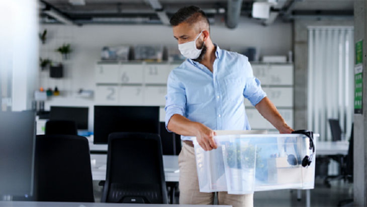 Man carrying a box in an office