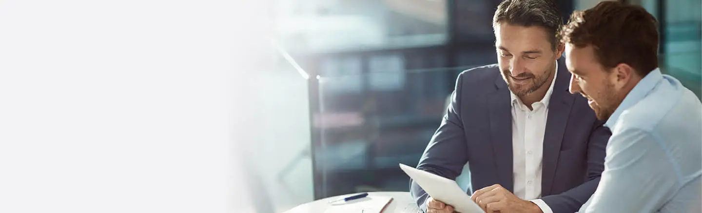 Two business professionals reviewing documents in an office setting, illustrating collaborative talent analytics and workforce planning consultancy.