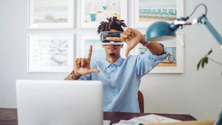 Man at desk wearing virtual reality visor