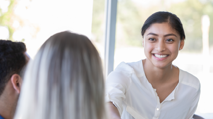 Young woman smiling at colleagues