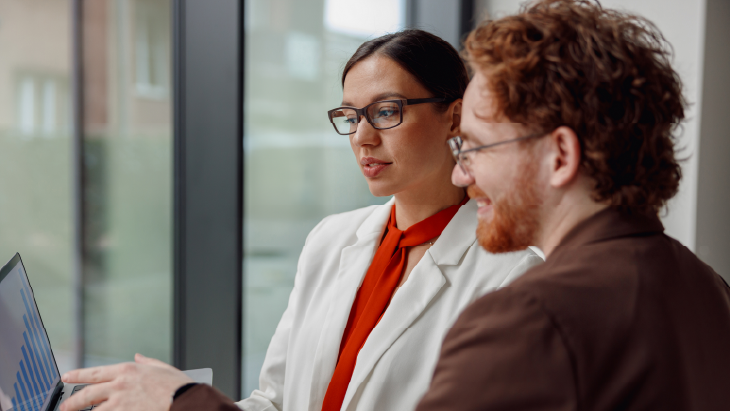 Finance professionals reviewing performance data together, illustrating the development of a finance shared service centre to support operational growth.