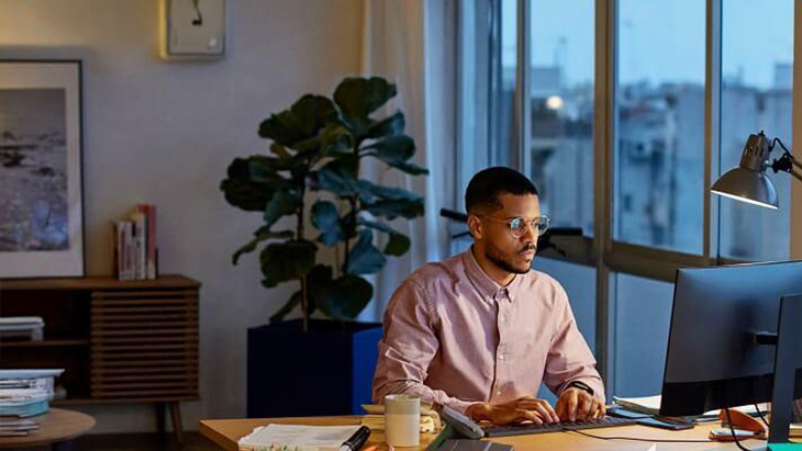 Man working on laptop in large living room