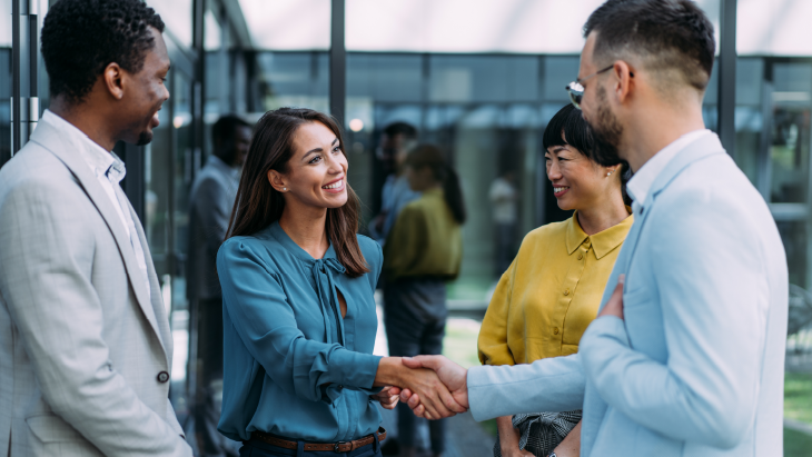 Senior professionals shaking hands in a modern office environment, representing successful executive search and global workplace leadership for a multinational semiconductor organisation.