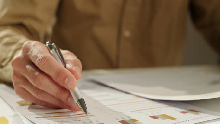 Financial documents and charts being reviewed at a desk, representing rapid transactional finance recruitment to support business continuity.