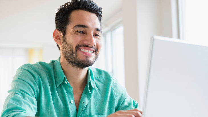 Man smiling and working on laptop