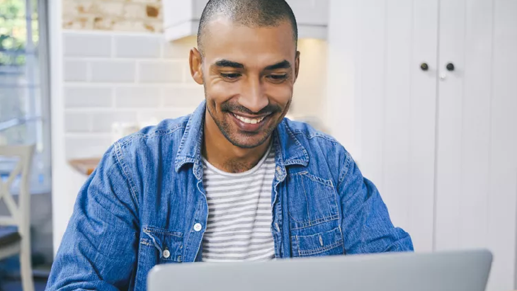 Man smiling and working on laptop