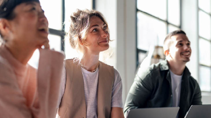 Colleagues collaborating in a modern office with laptops and natural light - illustrating UK hiring trends 2026 and the evolving world of work.