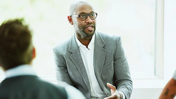 Man with glasses speaking to an audience about career lessons inspired by the gig economy