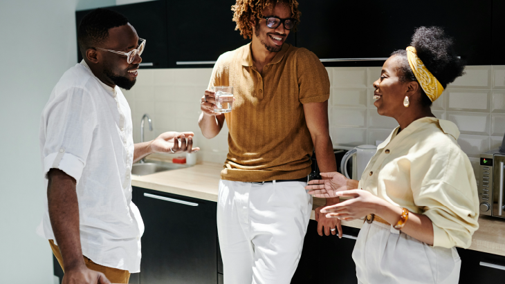 Colleagues laughing and talking in kitchen