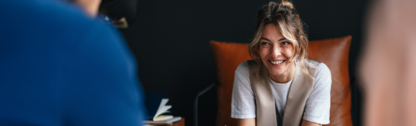 Banner for Hays UK Salary & Recruiting Trends 2026 guide with a person seated on a brown leather chair against a dark background.