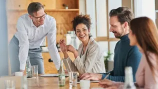 Professionals collaborating around a meeting table, representing structured workforce governance and managed service delivery in a regulated financial environment.
